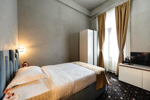 a hotel room with a bed and a television at Palace Bulevard Inn in Cluj-Napoca