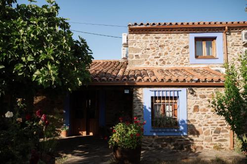 a stone house with a window and a fence at CASA RURAL La Moranta in Herguijuela