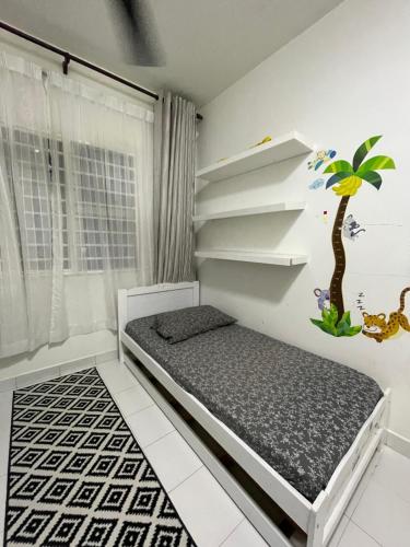 a small bedroom with a bed and a tree on the wall at Homestay Putrajaya in Putrajaya