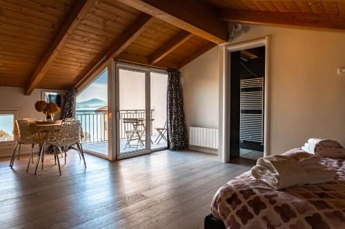 a bedroom with a bed and a table and a balcony at Residenza a schiera vista lago Feriolo in Feriolo