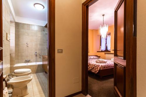 a bathroom with a toilet a sink and a bed at Residenza a schiera vista lago Feriolo in Feriolo