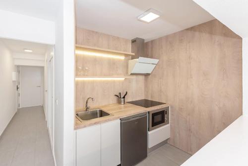 una cucina con lavandino e forno a microonde di Enkala Apartamentos a Ibiza Città