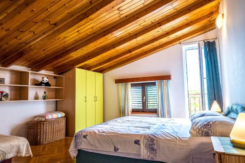 um quarto com 2 camas e um tecto de madeira em Apartmani Rosa em Turanj