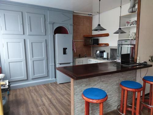 La cuisine est équipée d'un comptoir avec tabourets et d'un réfrigérateur. dans l'établissement Appartement cœur de ville., à Dole