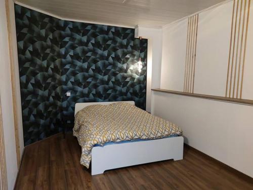une chambre avec un lit dans une chambre avec un mur dans l'établissement Appartement cœur de ville., à Dole