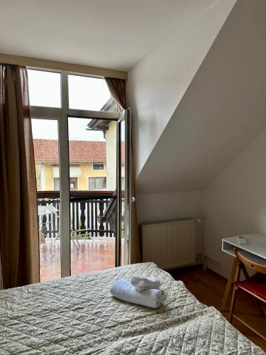 a bedroom with a bed and a large window at Karla’s House in Dobje pri Planini