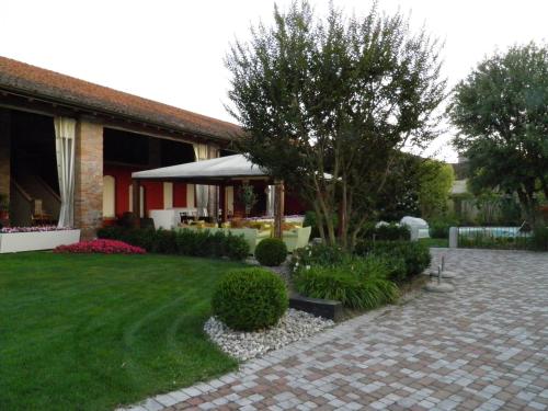 a house with a garden with a brick walkway at Affittacamere Il Persicone in Cornaleto