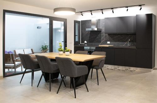 una cucina e una sala da pranzo con tavolo e sedie in legno di Domus Alba Apartment a Trapani