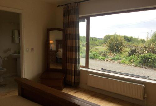 een kamer met een groot raam en een spiegel bij 3 bedroom home 15 mins drive from Kenmare town 