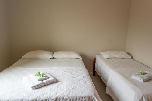 two beds in a room with towels on them at Pousada Estrada do Ouro in Angra dos Reis