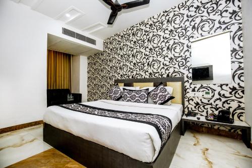 a bedroom with a bed with a black and white patterned wall at Hotel Tamanna - 50 Meter from Golden Temple in Amritsar