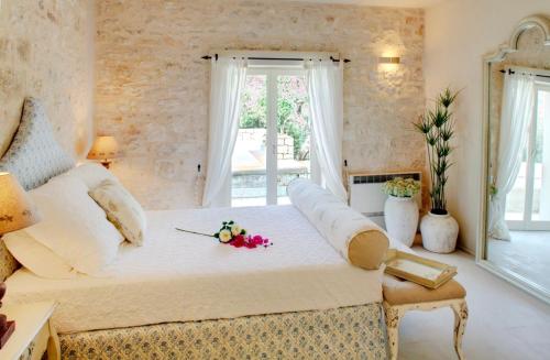 - une chambre avec un grand lit fleuri dans l'établissement Kallista House, à Kourtaíïka