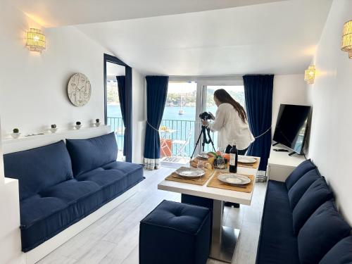 une femme prenant une photo d'un salon dans l'établissement MAISON BLEUE AP4362 By Riviera Holiday Homes, à Villefranche-sur-Mer
