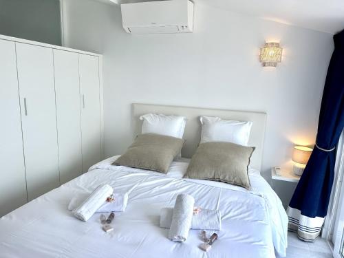 un lit blanc avec deux serviettes pour bébé dessus dans l'établissement MAISON BLEUE AP4362 By Riviera Holiday Homes, à Villefranche-sur-Mer