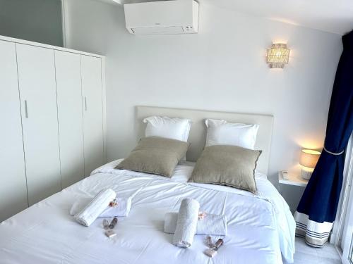 a white bed with two baby towels on it at MAISON BLEUE AP4362 By Riviera Holiday Homes in Villefranche-sur-Mer