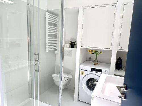 a white bathroom with a toilet and a washing machine at MAISON BLEUE AP4362 By Riviera Holiday Homes in Villefranche-sur-Mer