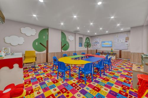 a classroom with a table and chairs on a colorful floor at Kahya Hotel in Alanya