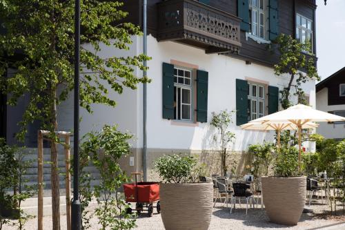 a building with tables and chairs and an umbrella at quartier - über Nacht in besonderer Architektur in Garmisch-Partenkirchen