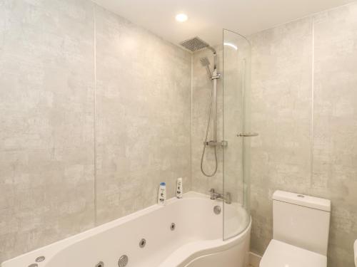 a bathroom with a tub and a toilet and a shower at Frankies Seaview 4 in Bridlington
