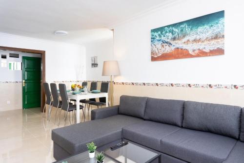 ein Wohnzimmer mit einem Sofa und einem Tisch in der Unterkunft Tre spaziosi appartamenti a 150m dal lungomare di Las Americas in Arona