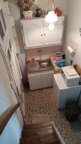 une petite cuisine avec un évier et un escalier dans l'établissement chez margaut, à Saint-Valery-sur-Somme