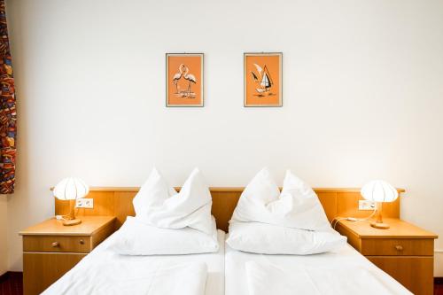 two beds in a hotel room with white pillows at PANORAMA SportHOTEL in Wenigzell