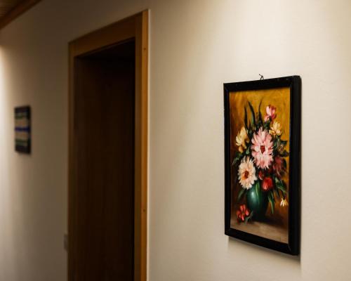 a picture of a painting of flowers on a wall at PANORAMA SportHOTEL in Wenigzell