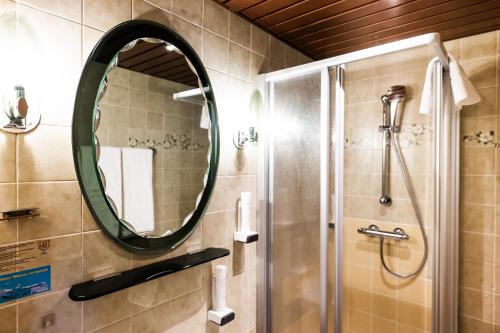 a bathroom with a shower and a mirror at PANORAMA SportHOTEL in Wenigzell