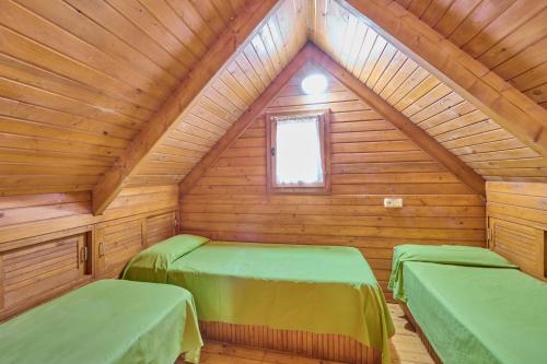 a room with two beds in a wooden cabin at Camping Fontfreda in Castellar del Riu