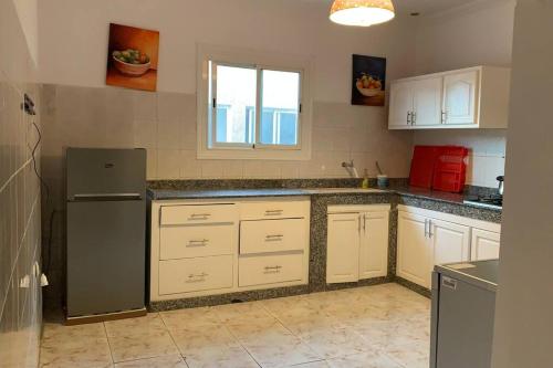  La cuisine est équipée de placards blancs et d'un réfrigérateur. dans l'établissement Mog'appart, à Essaouira