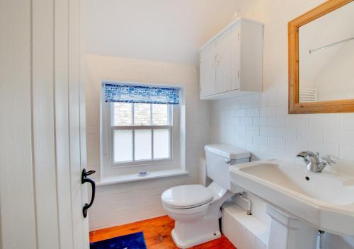 a white bathroom with a toilet and a sink at The Arc in Swanage