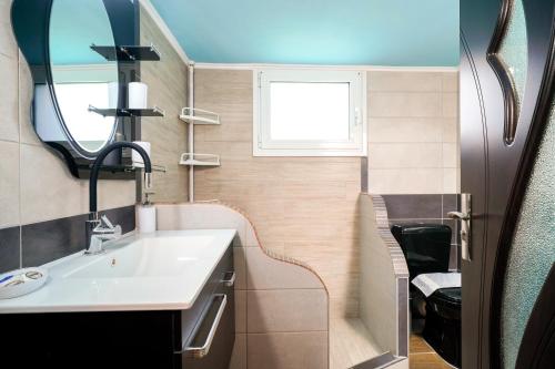 a bathroom with a sink and a mirror at Elia Villa Thassos in Prinos
