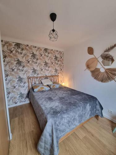 une chambre avec un grand lit avec une couverture bleue dans l'établissement Appartement cosy proche du tram, à Montpellier