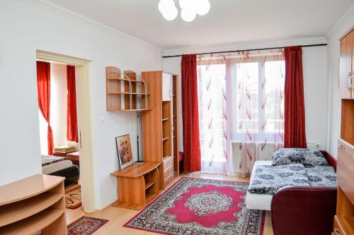 a bedroom with a bed and a window with red curtains at SovaApartman in Hajdúszoboszló