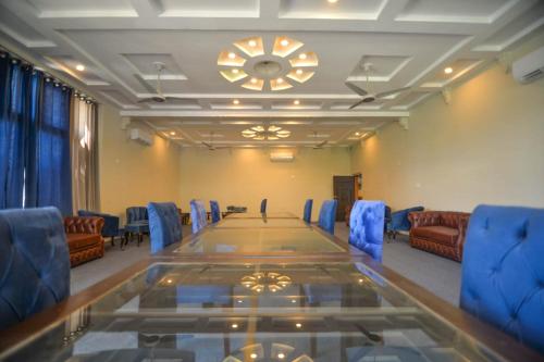 a conference room with a long table and blue chairs at Kallisto Hotel in Gilgit