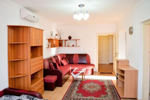 a living room with a red couch and a table at SovaApartman in Hajdúszoboszló