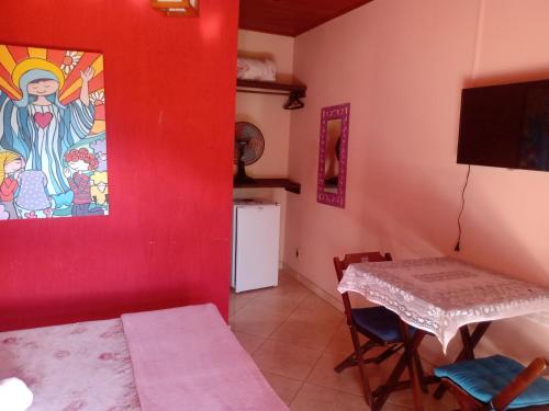 una habitación con una mesa y una pintura en la pared en Pousada luar da serra en Lumiar