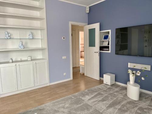 un soggiorno con pareti blu e scaffali bianchi di CENTRAL LOFT a Varese