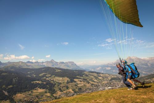 a person riding a paraglider on a mountain at Mamie Megève in Megève