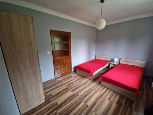 a room with two beds and a wooden floor at Cichy Zakątek Kłodzko in Kłodzko