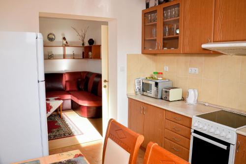 a kitchen with a microwave and a living room at SovaApartman in Hajdúszoboszló