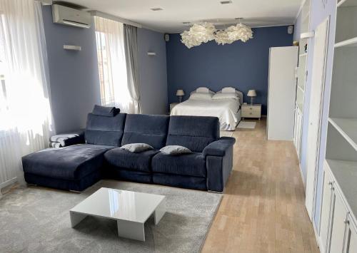 un soggiorno blu con divano e letto di CENTRAL LOFT a Varese