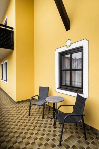 a room with two chairs and a table and a window at PANORAMA SportHOTEL in Wenigzell