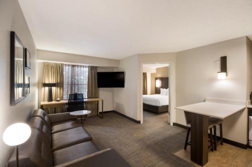 a hotel room with a couch and a bed at Sonesta ES Suites Dallas Richardson in Richardson