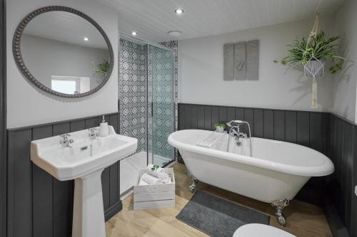 a bathroom with a tub and a sink and a mirror at Host & Stay - Acorn Cottage in Guisborough