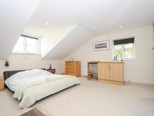 a white bedroom with a bed and a desk at Sherwell Farm Annexe in Callington