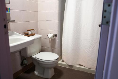 a bathroom with a white toilet and a sink at Residence & Conference Centre - Timmins in Timmins