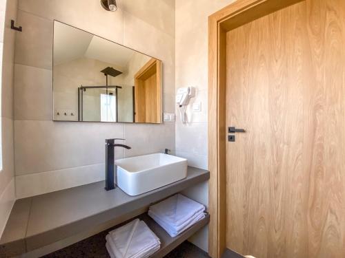 a bathroom with a sink and a mirror at Prowincja Dębki in Dębki