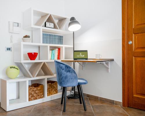 a room with a desk and a blue chair at The Park View Place in Olbia