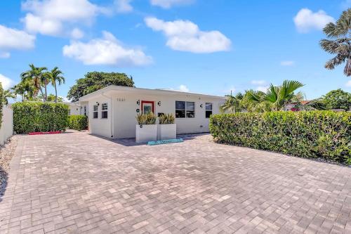 una casa blanca con palmeras delante en Soleil @ Casa Del Sol, en Fort Lauderdale